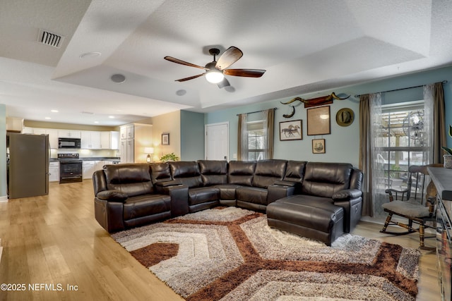54110 Marlee Rd, Callahan, FL 32011 - living room with a textured ceiling, light hardwood / wood-style floors, a raised ceiling, and ceiling fan