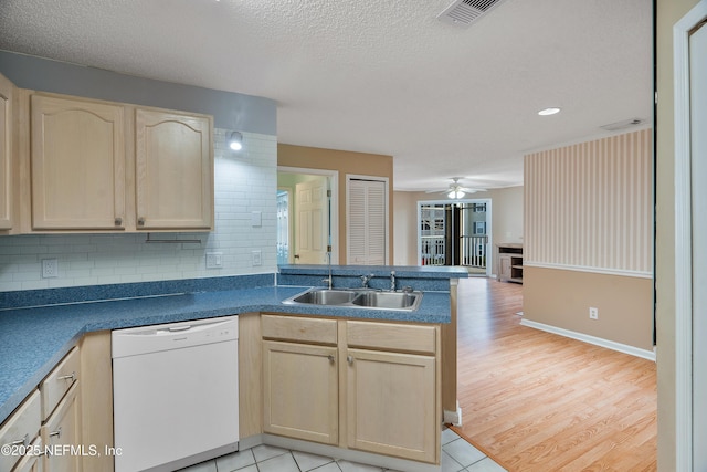 kitchen featuring light brown cabinetry, sink, white dishwasher, kitchen peninsula, and backsplash