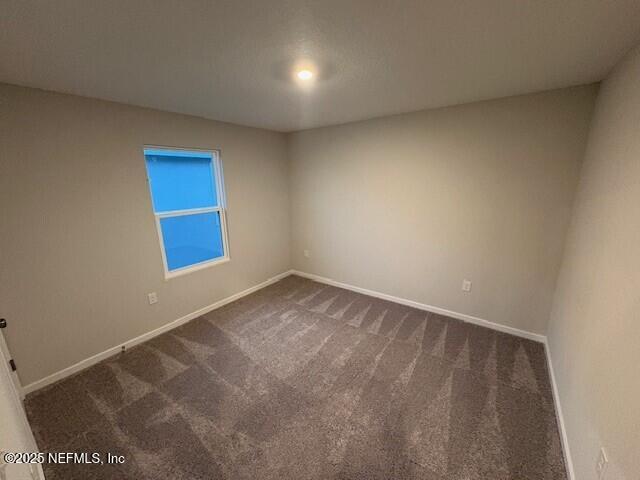 empty room featuring dark colored carpet