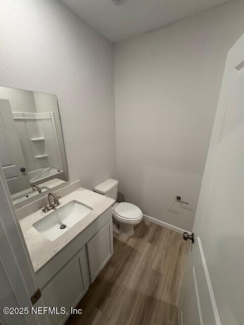 bathroom featuring hardwood / wood-style flooring, vanity, and toilet