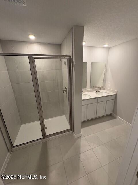 bathroom with tile patterned flooring, vanity, and a shower with shower door