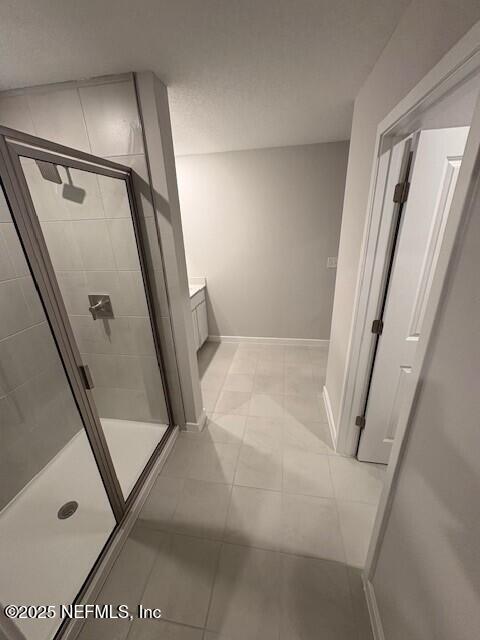 bathroom with vanity, tile patterned floors, and a shower with shower door