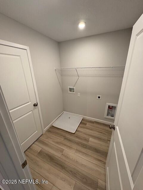 washroom featuring hookup for an electric dryer, washer hookup, and light wood-type flooring