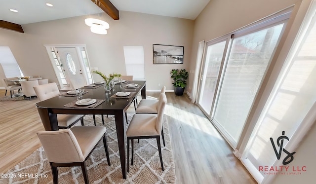 dining space featuring vaulted ceiling with beams and light wood-type flooring