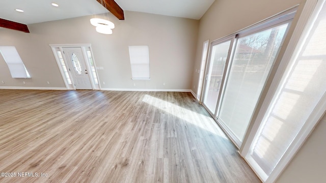 interior space with light hardwood / wood-style floors and vaulted ceiling with beams