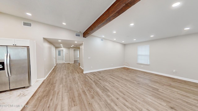 unfurnished living room featuring beam ceiling and light hardwood / wood-style floors