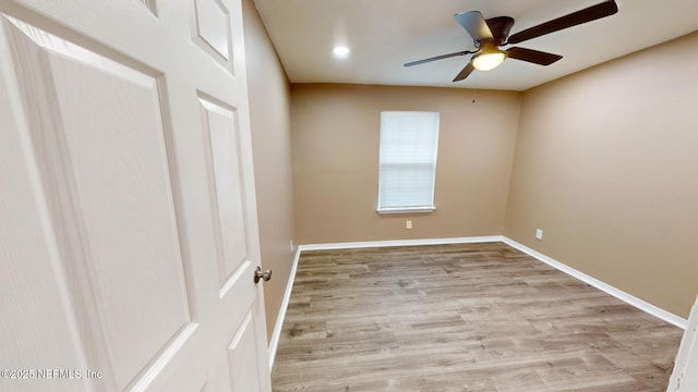 empty room with ceiling fan and light hardwood / wood-style flooring