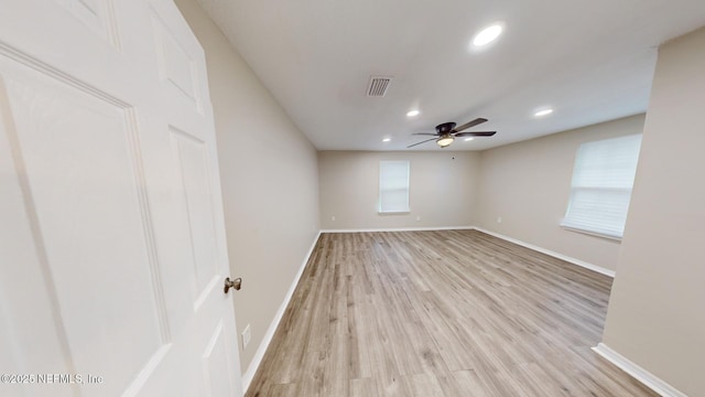 empty room with ceiling fan and light wood-type flooring