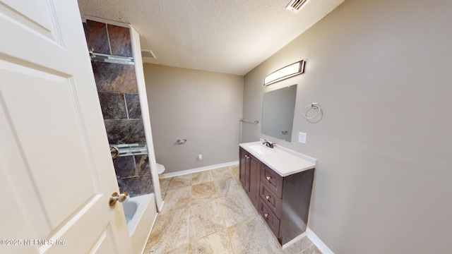 bathroom featuring vanity, a textured ceiling, and toilet