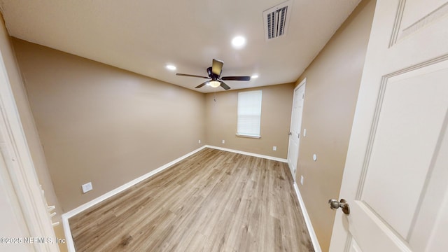 empty room with ceiling fan and light hardwood / wood-style floors