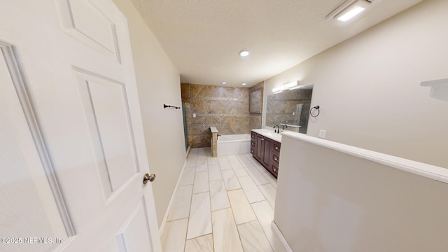 bathroom featuring vanity, independent shower and bath, and a textured ceiling