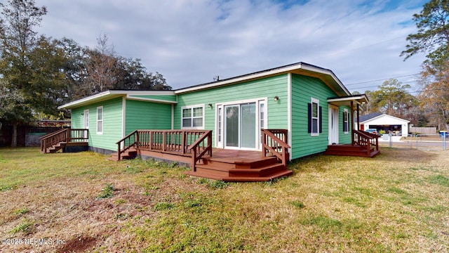 rear view of property featuring a yard and a deck