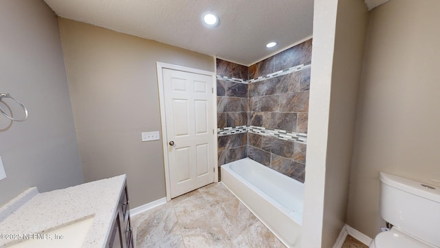 full bathroom with tiled shower / bath combo, vanity, a textured ceiling, and toilet