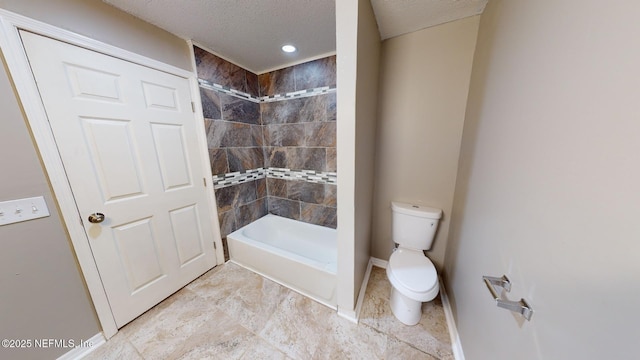 bathroom featuring toilet, a textured ceiling, and a tile shower