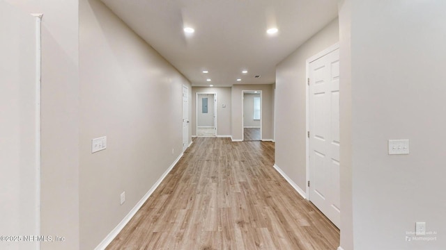 hallway with light hardwood / wood-style floors