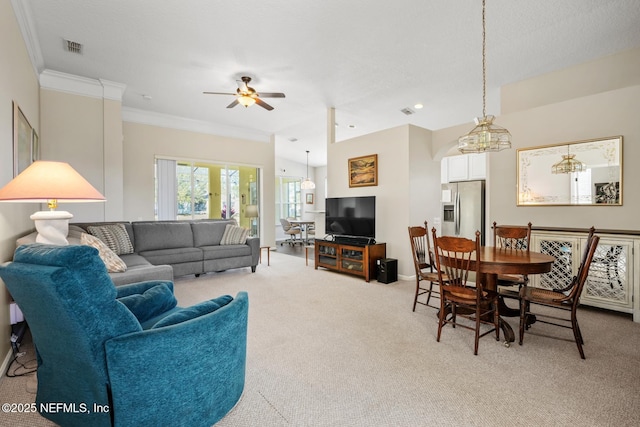 carpeted living room with ornamental molding and ceiling fan