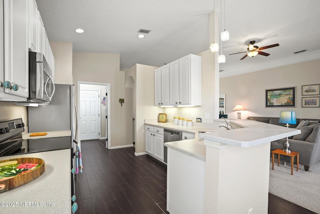 kitchen with white cabinetry, appliances with stainless steel finishes, a kitchen bar, and kitchen peninsula