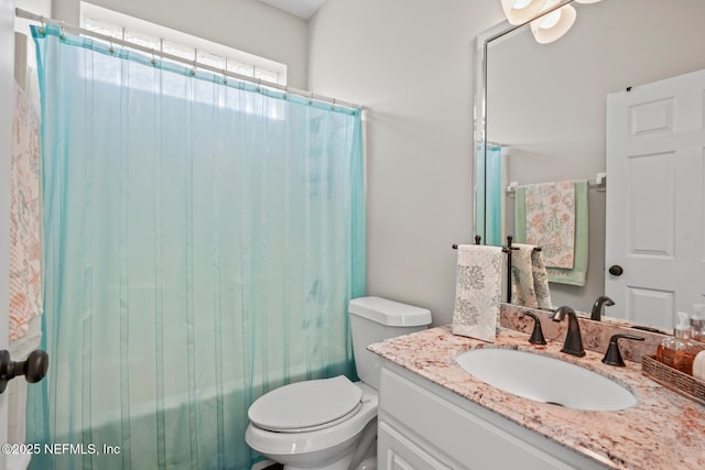 full bathroom with vanity, shower / tub combo with curtain, and toilet