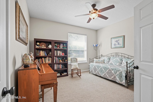 bedroom with ceiling fan, carpet floors, and a textured ceiling