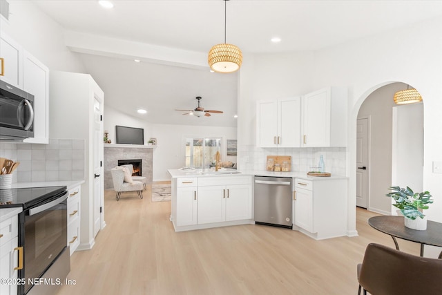 kitchen featuring pendant lighting, white cabinetry, stainless steel appliances, and kitchen peninsula