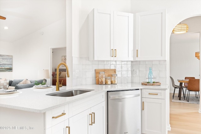 kitchen with lofted ceiling, sink, white cabinetry, tasteful backsplash, and stainless steel dishwasher