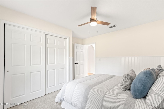 carpeted bedroom featuring ceiling fan and a closet