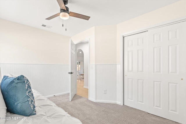 bedroom with light carpet, a closet, and ceiling fan