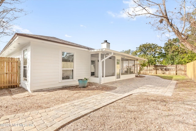 back of property featuring a sunroom and a patio