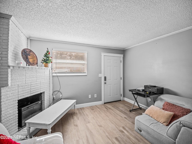 living room with light hardwood / wood-style flooring, a fireplace, ornamental molding, and a textured ceiling