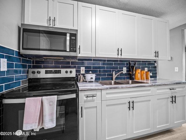 kitchen featuring white cabinetry, sink, tasteful backsplash, and appliances with stainless steel finishes