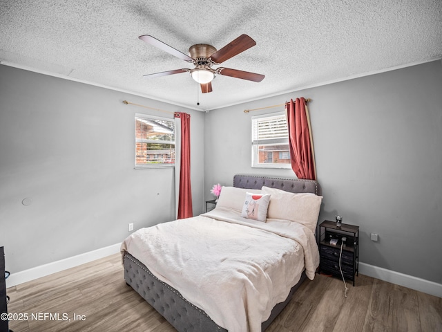 bedroom with wood-type flooring, ornamental molding, ceiling fan, and a textured ceiling