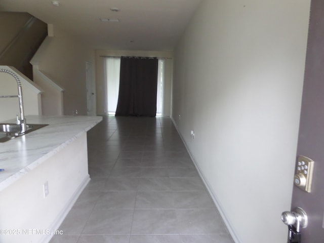 hallway featuring tile patterned flooring and sink