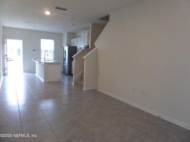 empty room featuring sink and light tile patterned floors