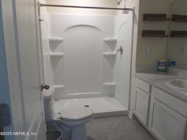 bathroom with a shower, toilet, tile patterned floors, and vanity