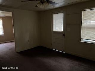 carpeted spare room featuring ceiling fan