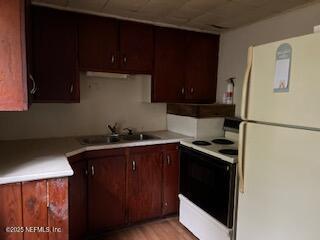 kitchen featuring white appliances, sink, and light wood-type flooring