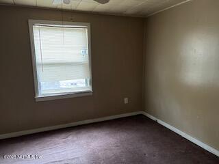 spare room featuring ceiling fan and carpet