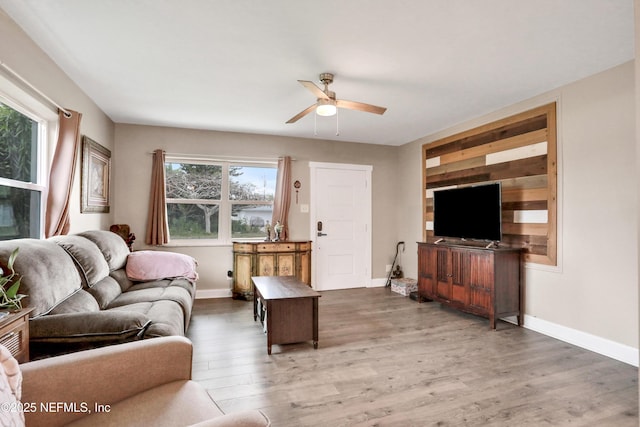 living room featuring ceiling fan, plenty of natural light, and dark hardwood / wood-style flooring