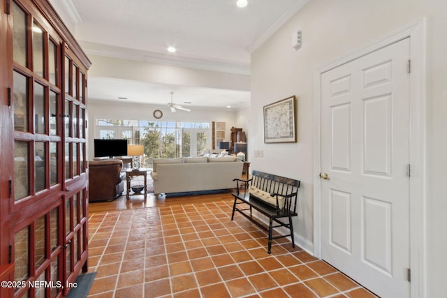 tiled foyer with ornamental molding and ceiling fan