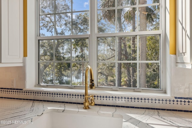 room details featuring light stone counters and white cabinets