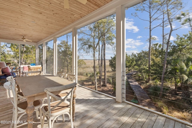 unfurnished sunroom featuring wood ceiling and ceiling fan