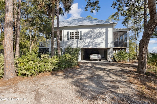 view of side of property with a sunroom and a carport