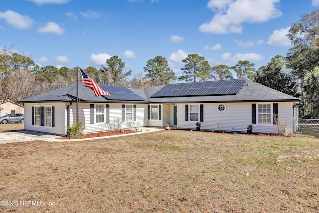 view of front of property featuring a front lawn and solar panels