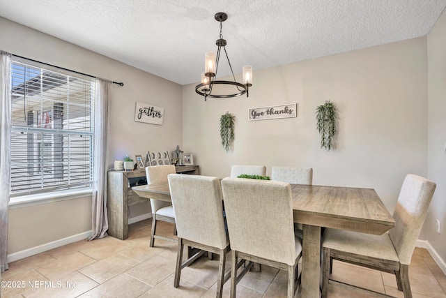 dining area with a textured ceiling, a chandelier, and light tile patterned flooring