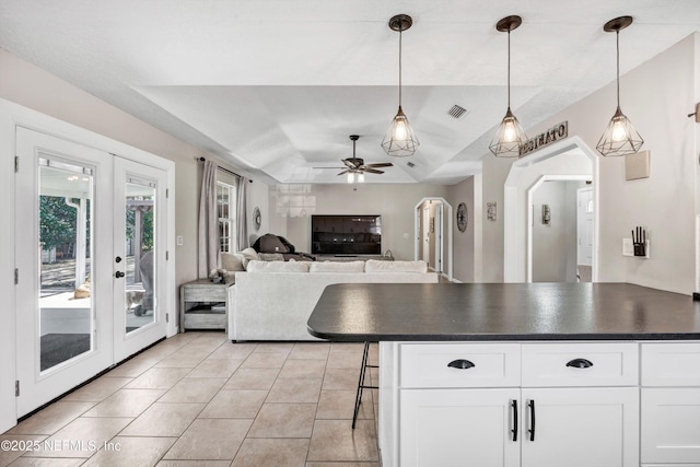 kitchen featuring white cabinetry, a breakfast bar area, light tile patterned floors, and decorative light fixtures