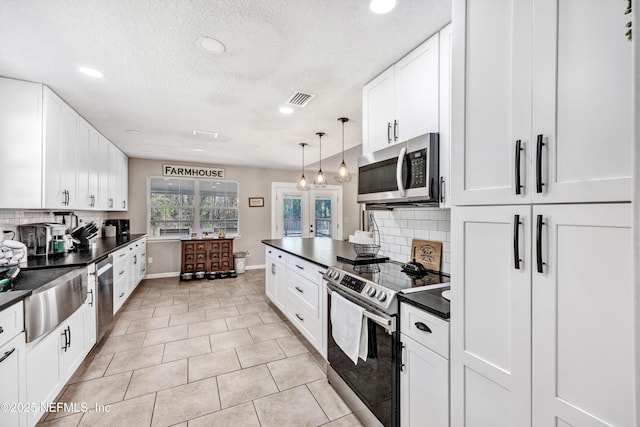 kitchen with white cabinetry, hanging light fixtures, light tile patterned floors, appliances with stainless steel finishes, and backsplash