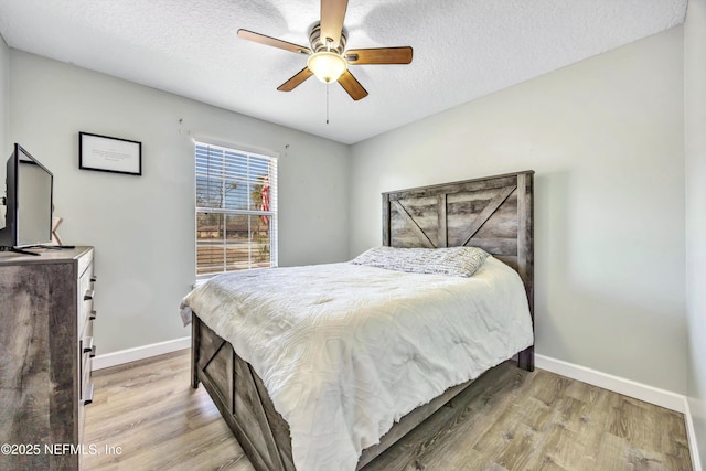 bedroom with ceiling fan, a textured ceiling, and light hardwood / wood-style flooring