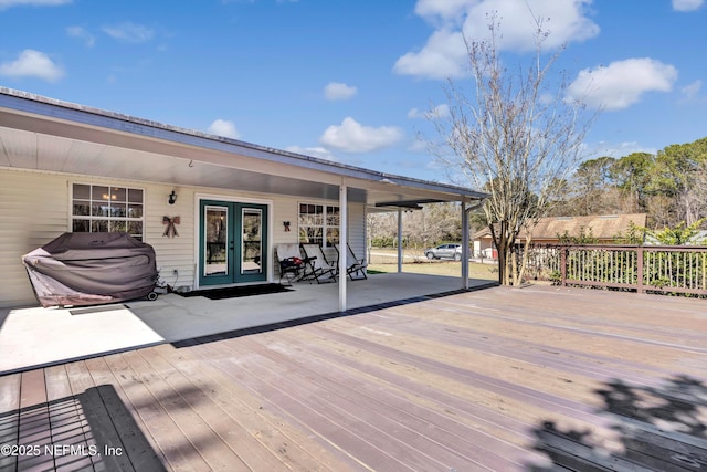 wooden terrace with area for grilling and french doors