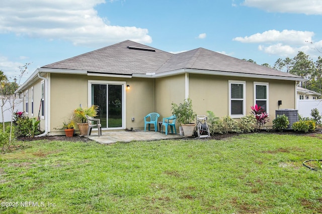 rear view of house with central AC unit, a yard, and a patio area