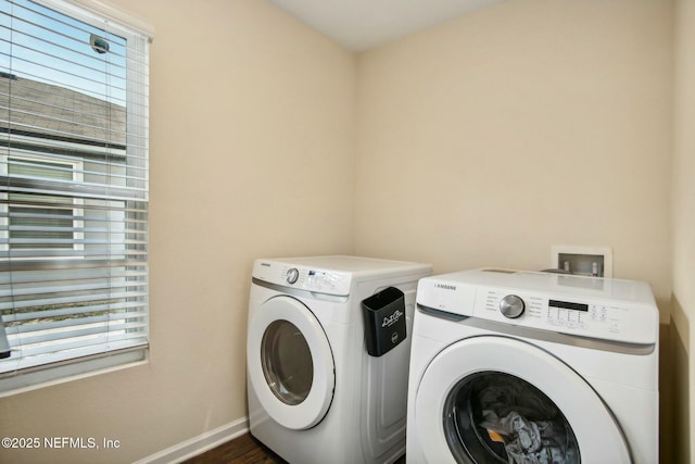 clothes washing area featuring washing machine and dryer and plenty of natural light